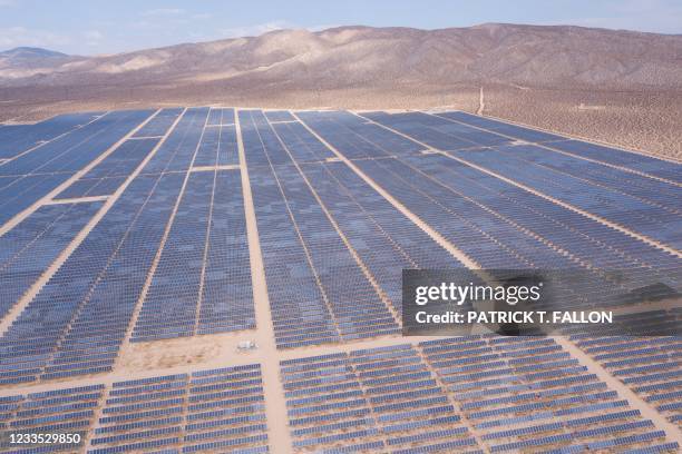 An aerial image shows solar panels part of an electricity generation plant on June 18, 2021 in Kern County near Mojave, California. - The California...