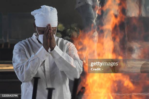 Golfer Jeev Milkha offer prayers in front of the funeral pyre of his dad and track legend Milkha Singh, who died aged 91 following a long battle with...