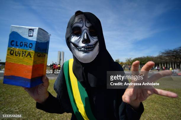 Demonstrator wearing a costume with a presidential sash and a box of the drug chloroquine, whose use was defended by President Jair Bolsonaro, during...