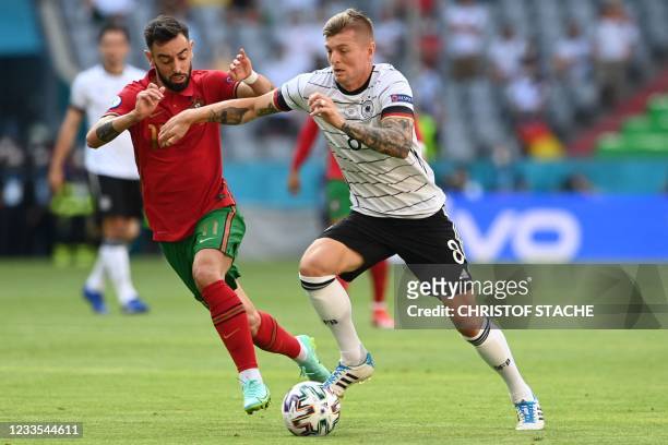 Portugal's midfielder Bruno Fernandes challenges Germany's midfielder Toni Kroos during the UEFA EURO 2020 Group F football match between Portugal...