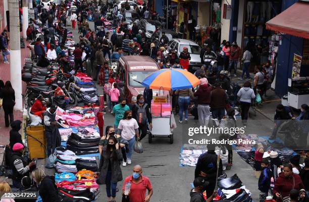 Shoppers walk through a busy shopping street of downtown Sao Paulo on June 19, 2021 in Sao Paulo, Brazil. According to the press group of various...