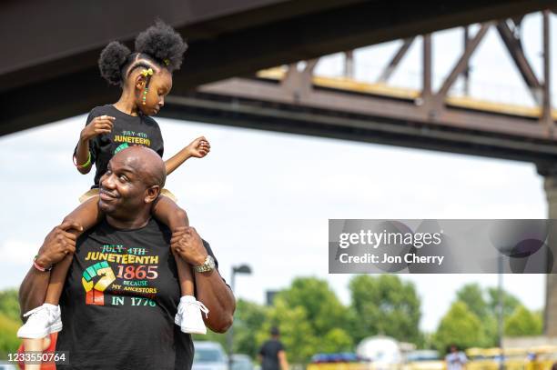 Young girl sits on a man's shoulders during the Louisville Juneteenth Festival at the Big Four Lawn on June 19, 2021 in Louisville, Kentucky....