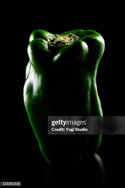 bell pepper is illuminated black background - grüne paprika stock-fotos und bilder