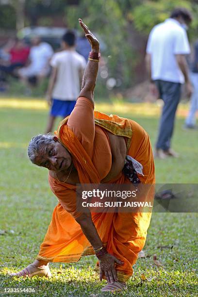 In this photograph taken on June 4, 2021 an elderly lady performs Yoga ahead of the International Yoga day in a public park in Mumbai.