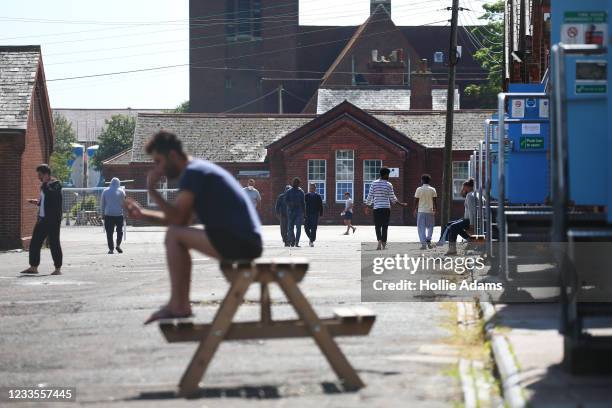 People walk around the exercise yard inside Napier Barracks on June 20, 2021 in Folkestone, England. A recent UK High Court ruling determined that...