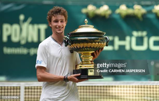 France's Ugo Humbert celebrates with the trophy after winning the ATP 500 Halle Open tennis tournament in Halle, western Germany, on June 20, 2021.