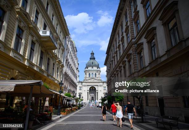 June 2021, Hungary, Budapest: Passers-by walk along a pedestrian street in front of St. Stephen's Basilica in the Pest district of the city. Photo:...