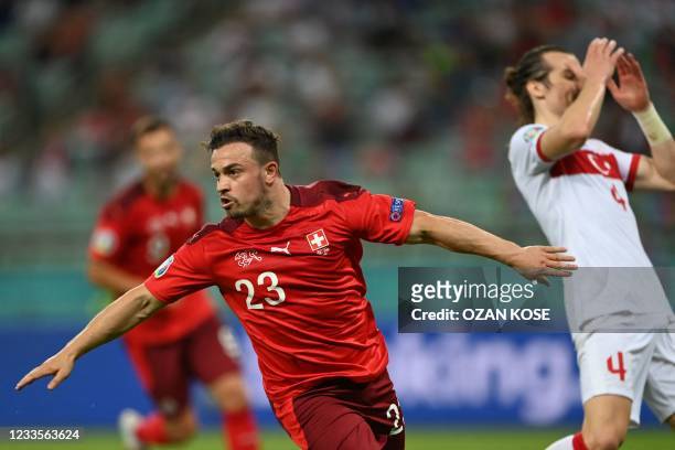 Switzerland's midfielder Xherdan Shaqiri celebrates scoring his team's third goal as Turkey's defender Caglar Soyuncu reacts during the UEFA EURO...