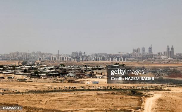 This picture taken on June 8, 2021 shows a view of the unrecognised bedouin village of Sawaneen in Israel's southern Negev region, and the skyline of...