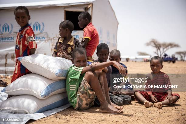 Children seat by their shelter in Goudebou, a camp that welcomes more than 11,000 Malian refugees in northern Burkina Faso, on International Refugee...