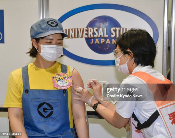 Universal Studios Japan staff member receives a COVID-19 vaccine in Osaka on June 21 under the theme park's mass vaccination program for its 10,000...