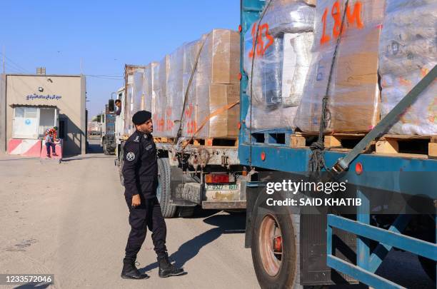 Palestinian police officer searches a truck's fabrics cargo slated for export at the Karm Abu Salem crossing in Rafah in the southern Gaza Strip,...