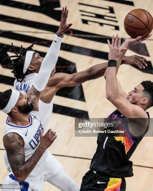 Sunday, June 20 Phoenix, Arizona - Phoenix Suns guard Devin Booker shoots over the defense of LA Clippers guard Terance Mann and LA Clippers forward...