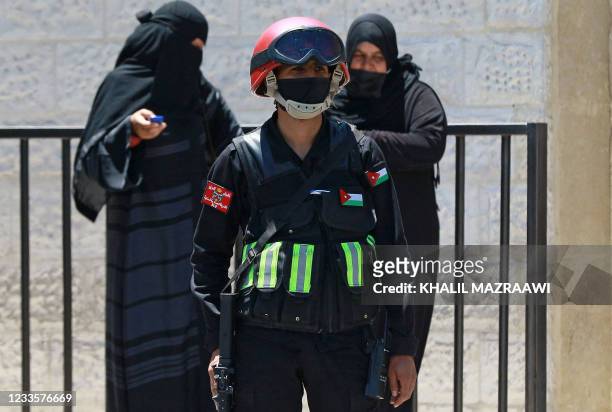 An officer stands guard outside the State Security Court, where the trial of two officials accused of helping Jordan's Prince Hamzah try to overthrow...