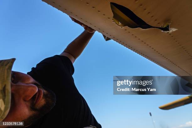 An airman checks for damage caused by gunfire from the Taliban on the UH-60, an aircraft lauded by crew for its survivability under fire, at Kandahar...