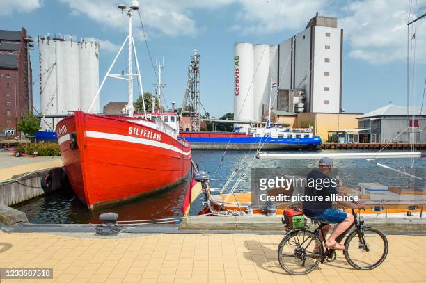 June 2021, Schleswig-Holstein, Fehmarn: The multi-purpose vessel "Jeanny" and the "MS Silverland" are moored in a pier in the municipal port of...