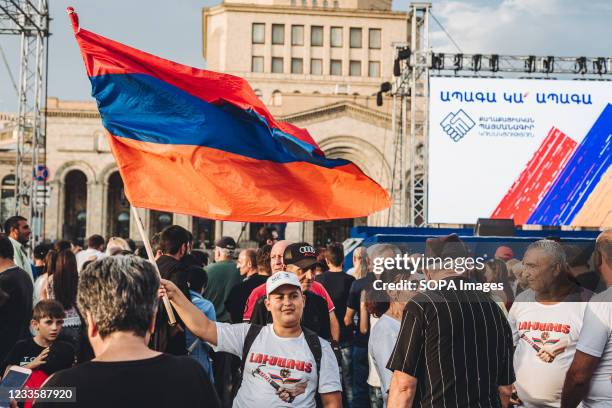 Supporter of Nikol Pashinian holds an Armenian flag during the victory celebration of Nikol Pashinyan in Armenia's parliamentary elections in...