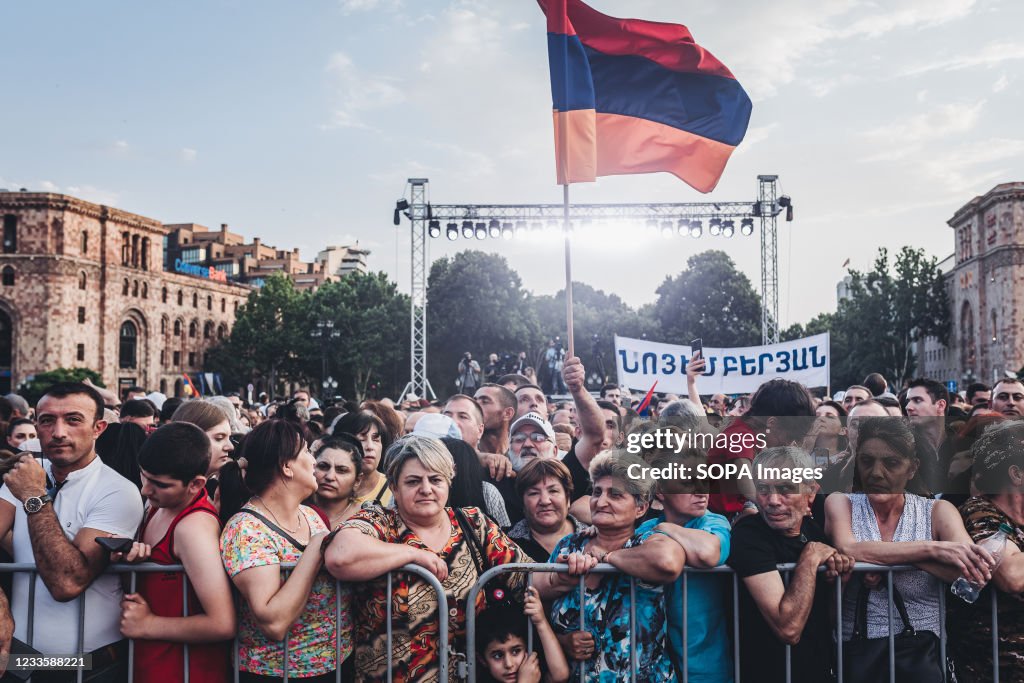 A supporter of Nikol Pashinian holds an Armenian flag during...