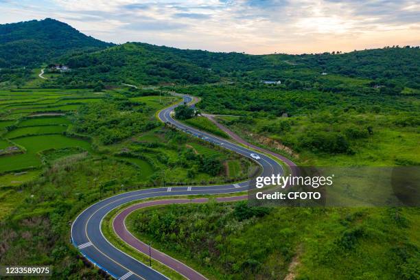 Vehicles drive on Qingtian Road in Baogong Town, Feidong County, Hefei City, Anhui Province, China, June 21, 2021. The county built a 5.1 km long...