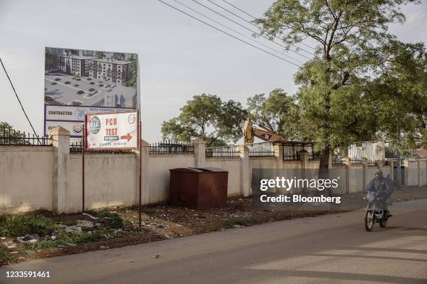 Motorcycle taxi, known locally as boda-boda, drives past a sign for a Covid-19 PCR testing site in Juba, South Sudan, on Sunday, June 6, 2021. South...