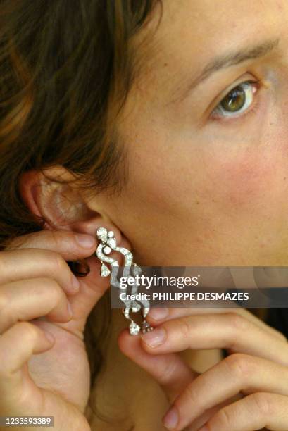 Une cliente essaye, le 17 juin 2002, une parure Cascade, diamants et or blanc dans la joaillerie Fred du 7 place Vendôme à Paris. Ce célèbre...