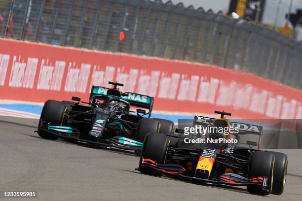 Max Verstappen of Netherlands driving the Red Bull Racing RB16B Honda and Lewis Hamilton of Great Britain driving the Mercedes AMG Petronas F1 Team...