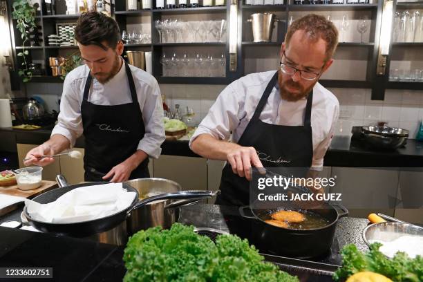 Israeli chef Shachar Yogev and his assistant Itamar Whiteson prepare burgers made with "cultured chicken" meat at a restaurant adjacent to the...