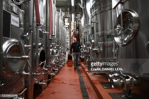 Worker inspects vats of wine at Ridgeview Estate's winery near Burgess Hill, southern England, on June 22, 2021. Problems have shaken the lives of...