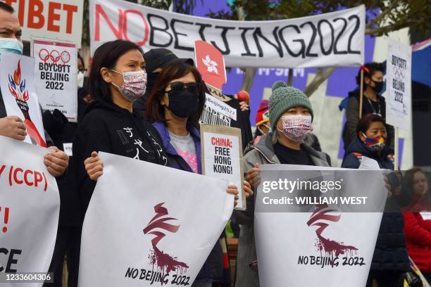 Activists including members of the local Hong Kong, Tibetan and Uyghur communities hold up banners and placards in Melbourne on June 23 calling on...