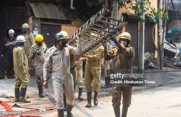 Firefighters working to douse a fire in a footwear factory in Udyog Nagar, on June 21, 2021 in New Delhi, India. A massive fire broke out at a shoe...