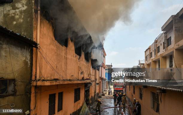 Smoke billows from a fire in a footwear factory at Udyog Nagar, on June 21, 2021 in New Delhi, India. A massive fire broke out at a shoe factory in...