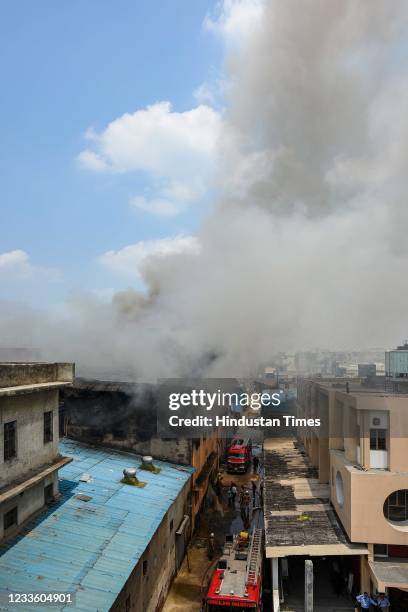 Smoke billows from a fire in a footwear factory at Udyog Nagar, on June 21, 2021 in New Delhi, India. A massive fire broke out at a shoe factory in...