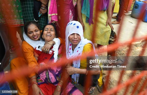 Family members of workers missing mourn after a fire in a footwear factory in Udyog Nagar, on June 21, 2021 in New Delhi, India. A massive fire broke...