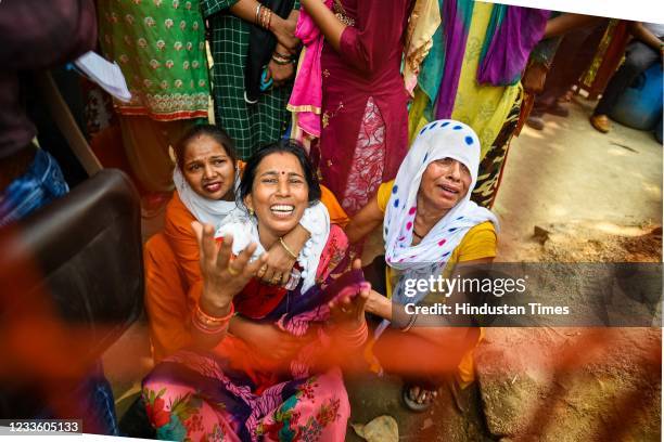 Family members of workers who are missing mourn after a fire broke out at a shoe factory, at Udyog Nagar, on June 21, 2021 in New Delhi, India. A...