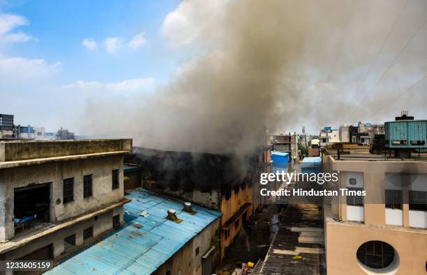 Smoke billows from a fire in a footwear factory at Udyog Nagar, on June 21, 2021 in New Delhi, India. A massive fire broke out at a shoe factory in...