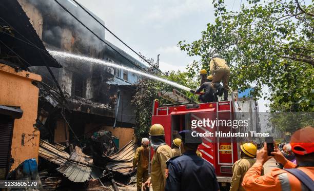 Firefighters working to douse a fire in a footwear factory in Udyog Nagar, on June 21, 2021 in New Delhi, India. A massive fire broke out at a shoe...
