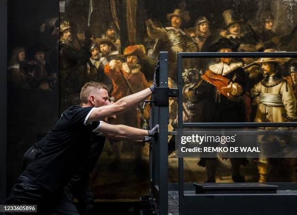 An employee moves scaffolding from in front of the 1642 'Night Watch'at the Rijksmuseum Museum during 'Operation Night Watch', the largest ever...