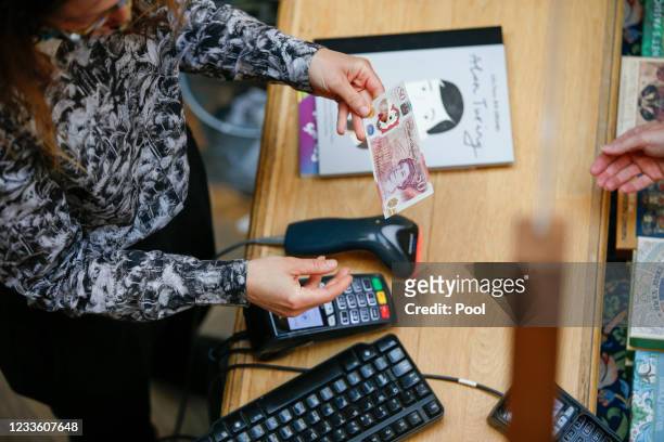 Sarah John, chief cashier of the Bank of England, uses a new 50-pound banknote at Daunt Books on June 23, 2021 in London, England. The new £50 note...