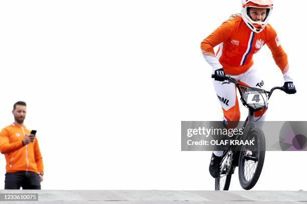 Dutch BMX rider Judy Baauw rides as national BMX coach Raymon van der Biezen checks his phone during a demonstration of a new digital technique on...