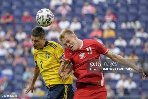 Sweden's defender Mikael Lustig jumps for the ball with Poland's forward Karol Swiderski during the UEFA EURO 2020 Group E football match between...