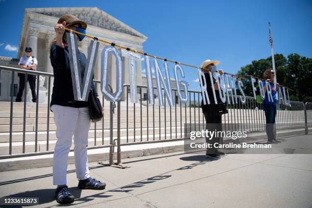 Demonstrators hold up a sign as they participate in the Moral March on Manchin and McConnell, a rally held by the Poor Peoples Campaign, calling on...