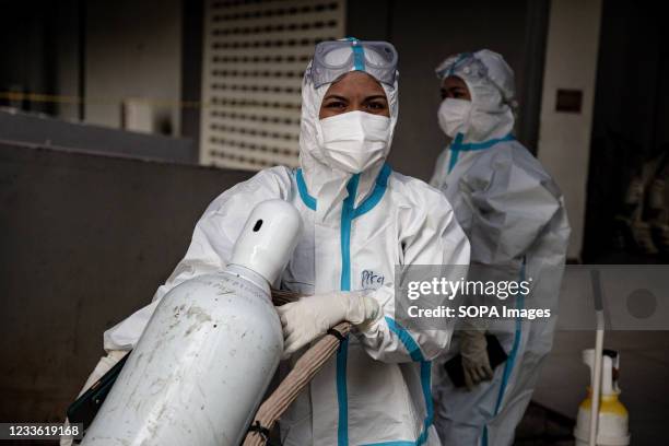 Health workers wearing Personal Protective Equipment are seen pushing oxygen cylinders inside the Wisma Atlet Covid-19 Emergency Hospital complex....