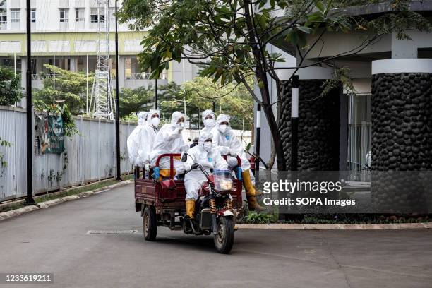 Workers wearing Personal Protective Equipment are seen on a motorcycle cart inside the Wisma Atlet Covid-19 Emergency Hospital complex. The Wisma...