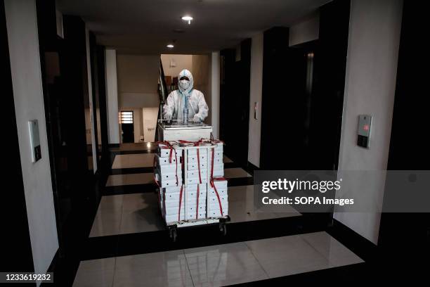 Health worker wearing a Personal Protective Equipment pushes a food cart inside the Wisma Atlet Covid-19 Emergency Hospital complex. The Wisma Atlet...