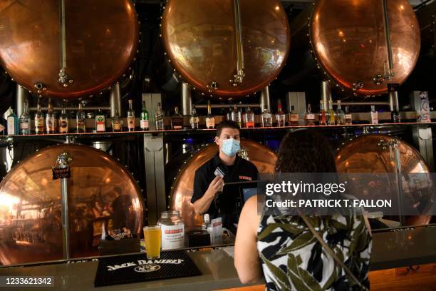 Bartender assists customers with a purchase at The Brew Hall on June 23, 2021 in Torrance, California.