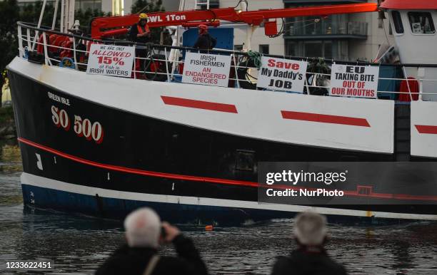 Locals observe fishing boats leaving Dublin as they sail down the River Liffey this evening. Fishermen protested in Dublin today against a lack of...