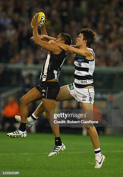 Andrew Krakouer of the Magpies marks in front of Andrew Mackie of the Cats during the round 24 AFL match between the Collingwood Magpies and the...