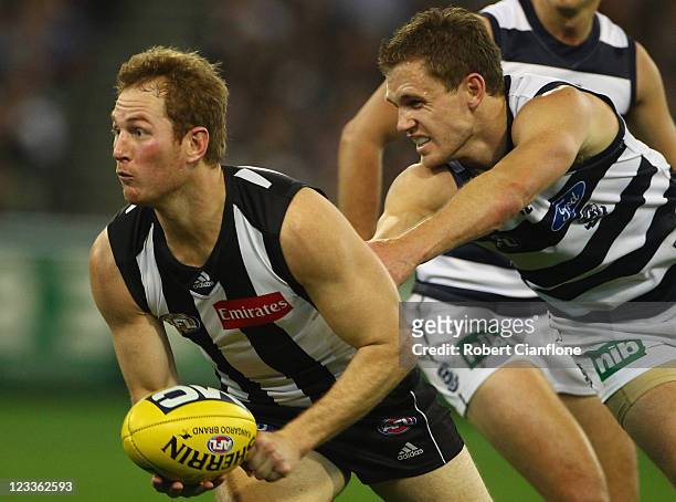 Ben Johnson of the Magpies looks to handball during the round 24 AFL match between the Collingwood Magpies and the Geelong Cats at Melbourne Cricket...