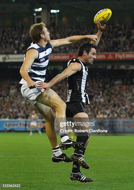 Darren Milburn of the Cats spoils the ball for Chris Tarrant of the Magpies during the round 24 AFL match between the Collingwood Magpies and the...
