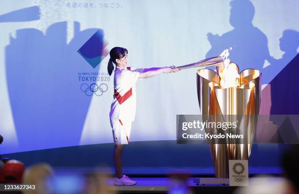 Barcelona Olympics 200-meter breaststroke gold medalist Kyoko Iwasaki transfers the Olympic flame to a cauldron after running in the Tokyo Olympic...